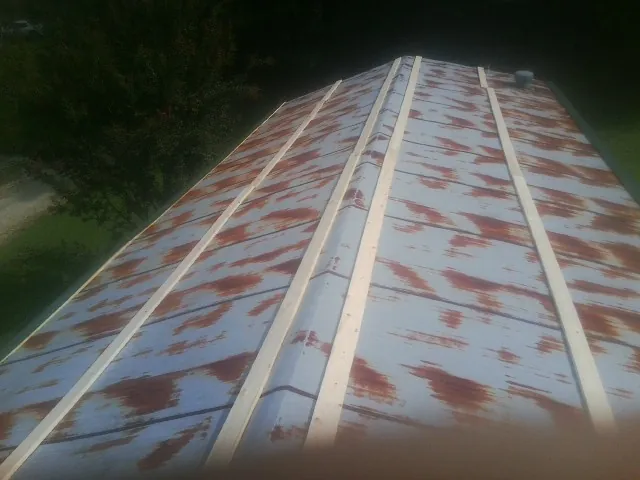 Rusted metal roof panels with new wood purlins before replacement — Storm Damage Roof Repair in Big Prairie by Roofing Brothers