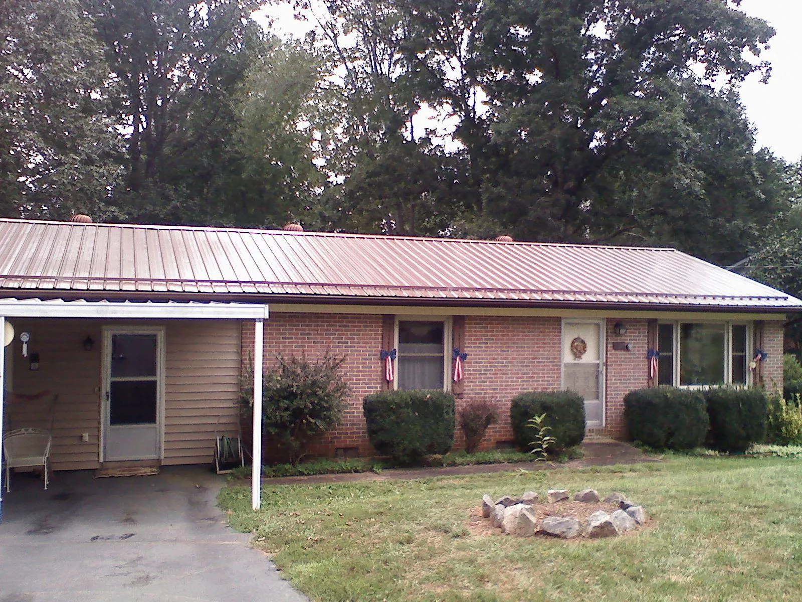 Bronze metal roof and carport on a brick ranch home — Roof Repair work by our crew in Big Prairie