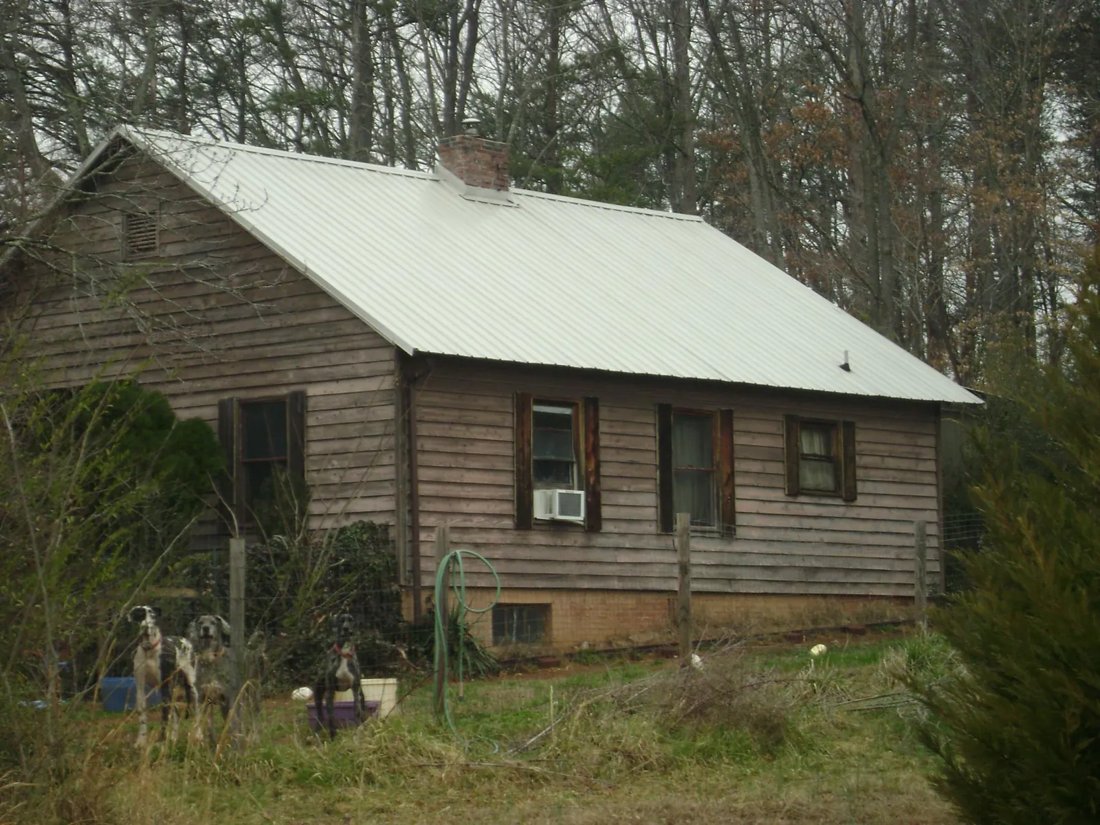 White metal roof on an old wood sided farmhouse, from a Metal Roof Installation job in Big Prairie